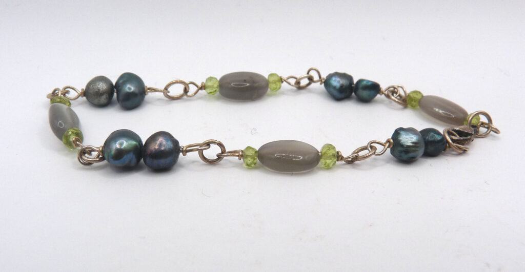 Silverarmband med grå månsten, peridot och pärlor.