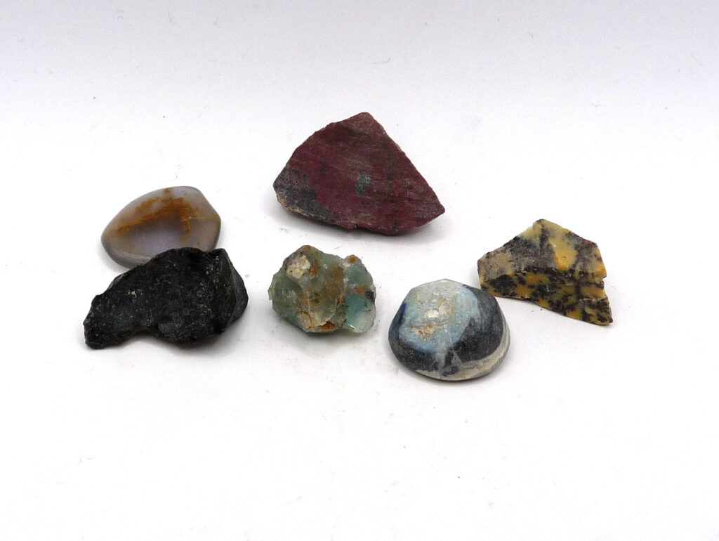 Grupp med ädelstenar: Opal, blå kalcedon, tektit, blå opal, röd jaspis och dendritisk opal.
